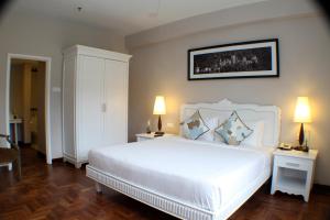 武吉丁宜Colmar Tropicale的一间卧室配有一张带两盏灯的大型白色床。