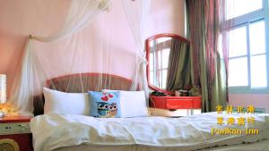 北港镇笨港客栈的一间卧室配有一张带大镜子的床