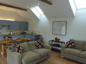 格拉斯顿伯里The Woodshed - A newly built, 2 bedroom, cottage near Glastonbury的一间带两张沙发的客厅和一间厨房