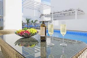 阿依纳帕Villa Paradisia的玻璃桌,带两杯酒杯和一碗水果