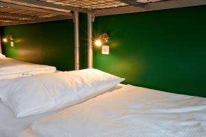 柏林博尔豪斯柏林旅舍的一间卧室设有两张带绿色墙壁的床。