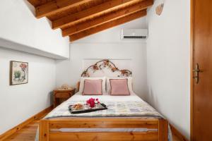 哈尔基岛Little Karafillias Chalki House的一间卧室配有带粉红色枕头的床