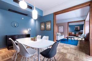 雅典The H Experience Boutique Apartments Athens的一间拥有蓝色墙壁和白色桌椅的用餐室
