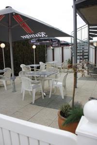 BarßelUmmen Hotel&Restaurant的庭院配有白色的桌椅和遮阳伞。
