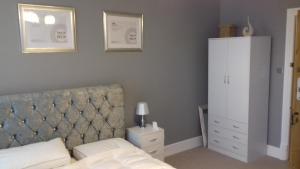 马基特德雷顿Lansdown House Bed & Breakfast的一间卧室配有一张带床头板的床和橱柜