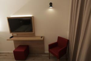 默费尔登-瓦尔多夫Galeria Airport Hotel的一间配有电视和红色椅子的房间