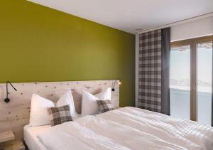 史多斯基普飞尔餐厅弗兰纳尔斯托克宾馆的一间卧室配有一张白色的床和绿色的墙壁