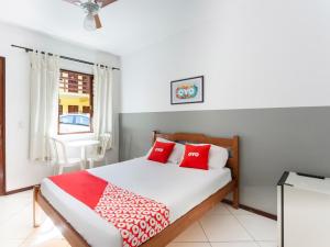 特雷索波利斯OYO Hotel Recanto Do Alto, Teresópolis的一间卧室配有红色和白色枕头的床