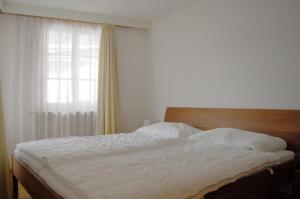 格林德尔瓦尔德Chalet Obelix的卧室配有白色的床和窗户