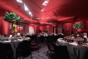 曼彻斯特voco Manchester - City Centre, an IHG Hotel的配有桌椅和红色灯光的房间