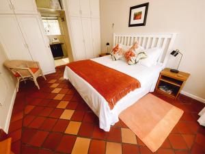 弗朗斯胡克Jonquil Guest Cottage的卧室配有一张白色的大床和一张桌子