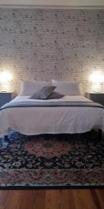 TollegnoAntico Affittacamere di Tollegno的卧室配有一张白色大床和砖墙