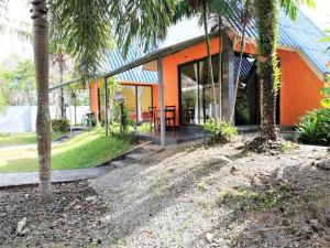 攀牙府Phurafa Resort的一座种植了棕榈树的橘子房子