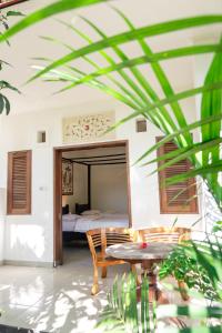 乌布巴厘岛巴提克斯卡尔民宿的一间卧室配有一张床、一张桌子和一张桌子