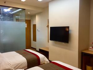 泉州尚客优酒店福建泉州丰泽区东海大街店的酒店客房设有两张床和一台平面电视。