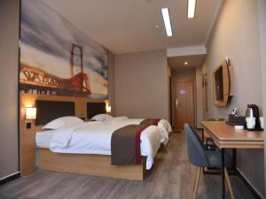 郑州尚客优酒店河南郑州未来路会展中心店的酒店客房设有一张大床和一张书桌。