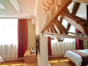 Kaika尚客优酒店西藏日喀则昂仁县县政府店的一间卧室设有楼梯,床配有红色窗帘