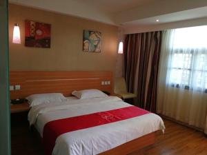 安顺尚客优酒店贵州安顺黄果树风景名胜区店的一间卧室设有一张大床和一个窗户。