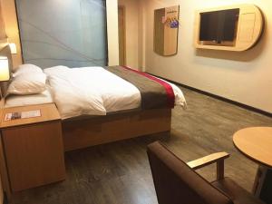 柳州尚客优酒店广西柳州鹿寨县广场店的一间酒店客房,配有一张床和一台电视