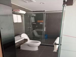Baima尚客优酒店西藏昌都八宿县县政府店的一间带卫生间和玻璃淋浴间的浴室