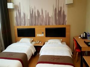 咸阳尚客优酒店陕西咸阳火车站店的酒店客房配有两张床和一张书桌