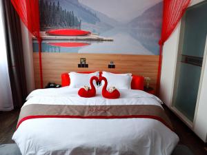 南通尚客优酒店江苏南通通州区先锋镇凯豪广场店的两个红色天鹅坐在床上