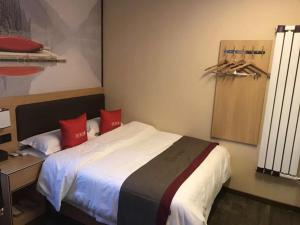 兰州尚客优酒店甘肃兰州城关区东方红广场店的一间卧室配有一张带红色枕头的大床