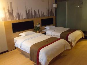 咸阳尚客优酒店陕西咸阳火车站店的酒店客房设有两张床,墙上挂有绘画作品