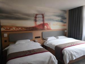 Baima尚客优酒店西藏昌都八宿县县政府店的两张位于酒店客房的床,墙上挂着一幅画