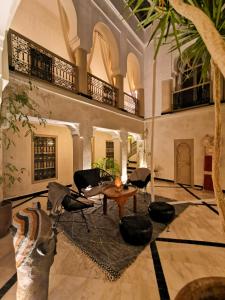 马拉喀什Riad Bamboo Suites & Spa的一个带桌椅的大客厅
