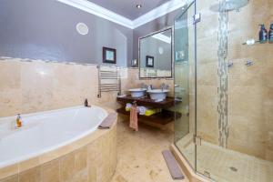 克尼斯纳亚历山大旅馆的一间带浴缸和淋浴以及两个盥洗盆的浴室