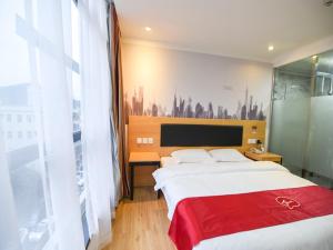 深圳尚客优酒店广东深圳机场后瑞地铁站店的一间卧室配有一张带红色毯子的大床