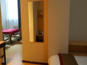 咸阳尚客优酒店陕西咸阳火车站店的一间设有床铺的房间和墙上的镜子