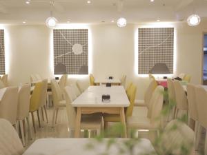 青岛尚客优精选山东青岛李沧区万年泉路店的用餐室设有桌椅和窗户。