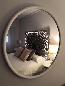 萨拉戈萨La Parada de Echegaray的卧室内的镜子反射着一张床