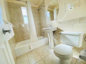 奥蒙德海滩A 1 A Super Inn的浴室配有卫生间、盥洗盆和浴缸。