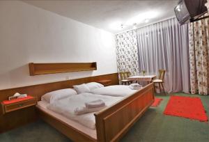 IrschenHotel Vanda的一间卧室配有一张大床和一张桌子