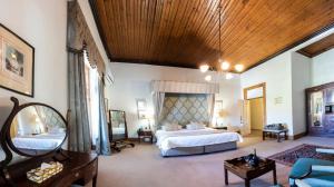 MatjiesfonteinLord Milner Hotel的一间大卧室,配有一张大床和木制天花板