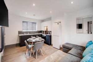 阿什福德Central location ideal for contractors, families and business travellers的厨房以及带桌椅的起居室。