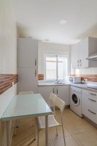 巴尔巴特Apartamentos Montedunas的厨房配有桌椅和洗衣机。
