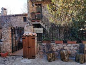 Riópar ViejoCasas Rurales el Olmo的石头建筑,有门和树