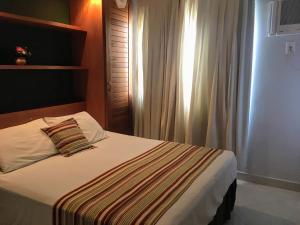 布希奥斯Pousada Marbella的一间卧室配有带条纹毯子的床