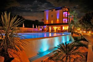 巴多利诺圣维托酒店的一座在晚上设有游泳池的大房子