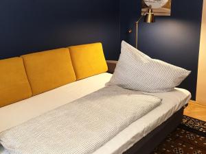 布达佩斯Madana apartman的一张带黄色床头板的床和两个枕头