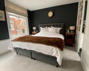 阿姆斯特丹The Lastage Inn - Bed & Breakfast的卧室配有一张大床,墙上挂着时钟