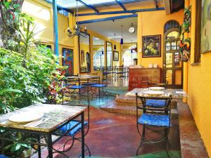 圣何塞Hotel Casa 69的一间设有桌椅的餐厅,种植了植物
