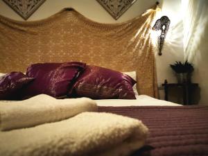 孔佩塔Apartamentos Alma y Montaña的一间卧室配有一张带紫色枕头的床和床头板