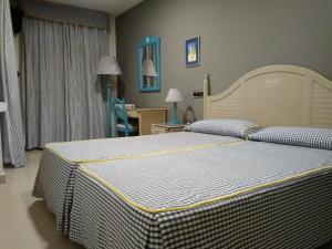 诺哈皮内达普拉亚酒店的一间卧室配有一张床和一张桌子及椅子