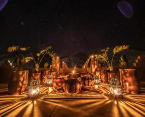 Aït IdaïrHotel Riad Bahammou的一张桌子,晚上有花瓶和灯
