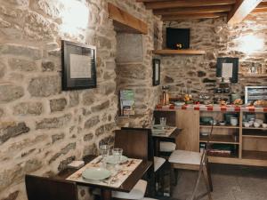 圣地亚哥－德孔波斯特拉PR纳斯圣胡安旅馆的一间设有两张桌子和石墙的餐厅